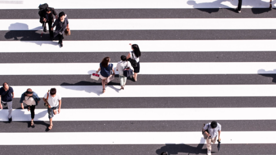 View of zebra crossing from above, with people walking across it.